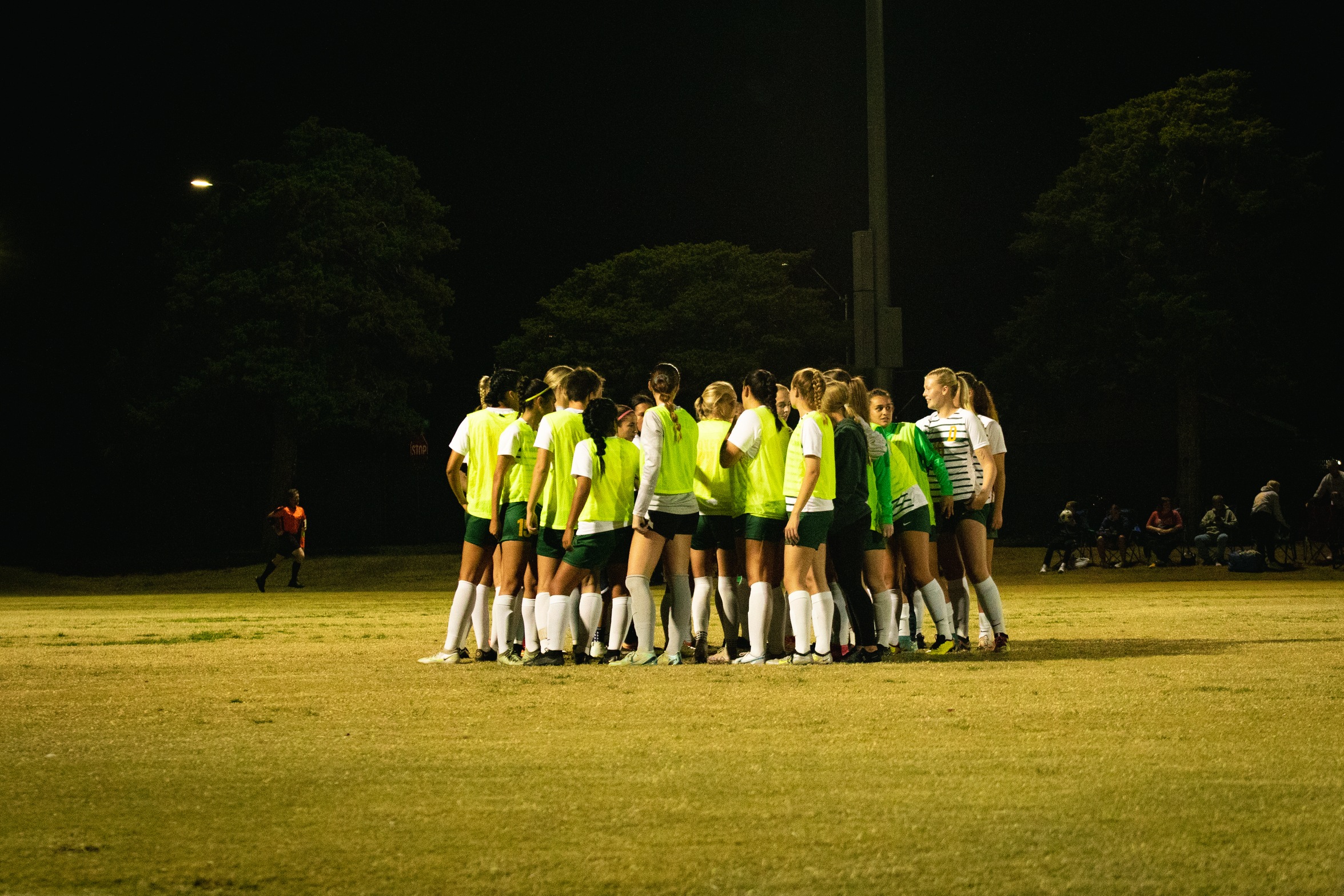 women's soccer team huddles before kick-off